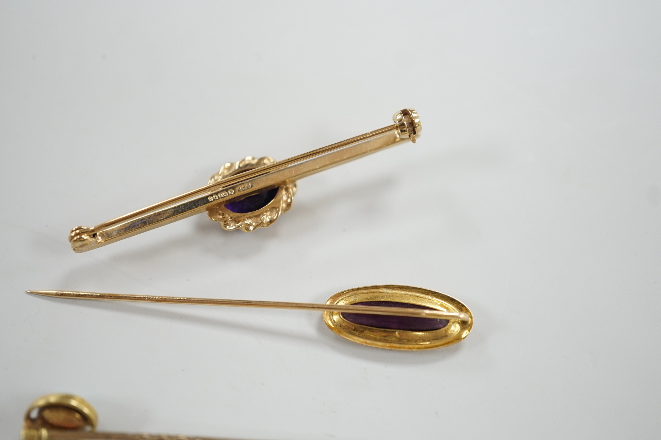 Three assorted yellow metal and gem set stick pins, including 9ct gold and diamond set horseshoe, 58mm and a modern 9ct gold and gem set bar brooch, gross weight 9.2 grams.